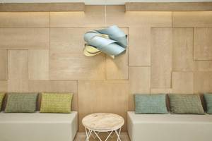 Innenansicht des Laguna Hotels mit Holzwand, Sofas, Tisch und Lampe.