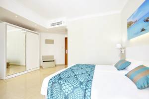Schlafzimmer im Lido Park Hotel mit Doppelbett, Deckenlampe, Spiegel und Gemälde.