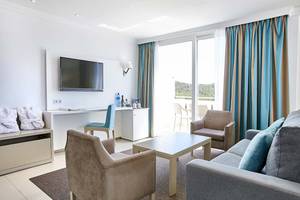 Innenansicht eines Hotelzimmers im Lido Park Hotel mit Fernseher, Schreibtisch und Balkon.
