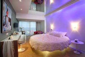 Schlafzimmer im Faros Hotel Ayia Napa mit violetten Lichtern und rundem Bett