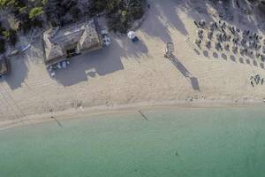 Luftaufnahme des Marques Hotels an einem Strand mit vielen Sonnenschirmen und Liegen.