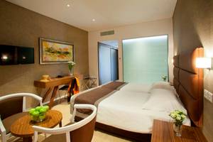 Schlafzimmer im Faros Hotel Ayia Napa mit zwei Betten, Tisch, Stühlen und Dekor.