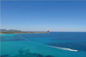 Luftaufnahme des Perla Hotels über dem blauen Ozean mit Parasailing