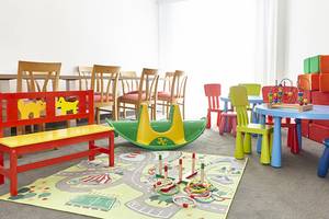Kinderspielzimmer im Perla Hotel mit bunten Möbeln und Spielzeug.