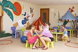 Kinder im Spielzimmer des Romantica Hotels, das mit bunten Wandmalereien und Spielzeug dekoriert ist.