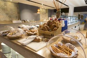 Frühstücksbuffet im Coral Costa Caribe Beach Resort mit Brot, Brötchen und Stöckchen.