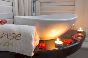 Ein Badezimmer im Coral Costa Caribe Beach Resort mit einem beleuchteten Waschbecken und einem Handtuch, das Sense & Salon beschriftet ist.