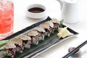 Sushi-Platte mit Gold bedeckt auf einem Teller neben einem Getränk im Katikies Villas Mykonos Hotel.
