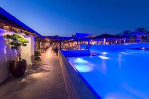 Der Außenbereich des Pools im Sandy Beach Hotel auf Kos bei Nacht mit blauer Beleuchtung.