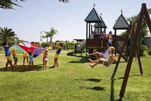 Kinder spielen auf einem Spielplatz im Freien im Sandy Beach Hotel auf Kos.