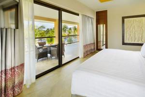 Schlafzimmer des Barcelo Maya Beach Hotels mit Terrasse und Ausblick auf den Pool.