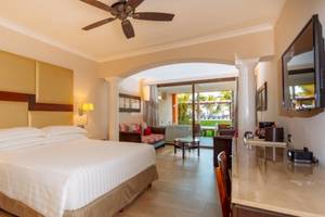 Hotelzimmer im Barcelo Maya Beach mit Bett, Schreibtisch und Klimaanlage.