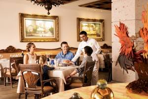 Familie in einem eleganten Restaurant des Barcelo Maya Beach Hotels, das Essen serviert wird