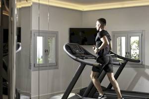 Mann im Fitnessraum der Katikies Villas Mykonos läuft auf einem Laufband.