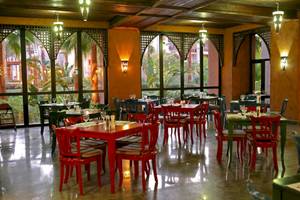Innenansicht des Restaurants im Pick Albatros Oasis Port Ghalib Hotel mit roten Tischen und Stühlen.