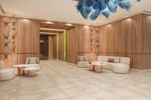 Innenbereich des Empfangsbereichs des Lago Hotels mit Holzwänden, Sitzmöbeln und einer großen Lampe.