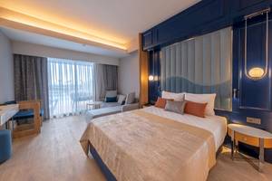 Hotelzimmer im Lago Hotel mit großem Bett, Sofa und Ausblick.