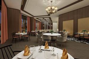 Innenansicht des Restaurants im Lago Hotel mit Tisch und Stühlen, Kronleuchter und Pflanzen.