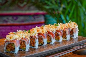 Mehrere Sushi-Rollen mit Toppings auf einer Holzplatte, serviert im Marriott Resort Palm Jumeirah, Dubai.