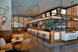 Innenansicht des Restaurants im Marriott Resort Palm Jumeirah, Dubai, mit Theke, Stühlen und Tischen.