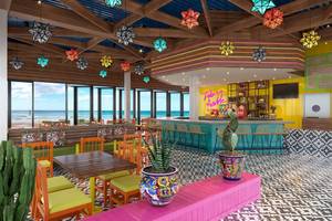 Innenansicht der Bar im Marriott Resort Palm Jumeirah, Dubai, mit bunten Dekorationen und Blick auf das Meer.