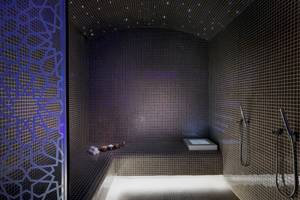 Sauna im Marriott Resort Palm Jumeirah, Dubai mit blauer Beleuchtung und quadratischen Fliesen.