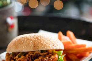 Ein Burger mit Beilagen auf einem Teller im Tower Hotel, London.