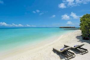 Strand des Constance Ephelia Mahe Seychelles Hotels mit zwei Liegen und blauem Ozean