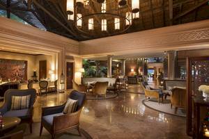 Lobby des Constance Ephelia Mahe Seychelles Hotels mit Sitzmöbeln und Kronleuchter.