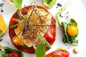 Gemüseplatte mit verschiedenen Tomaten und Blattgemüse auf einem weißen Teller