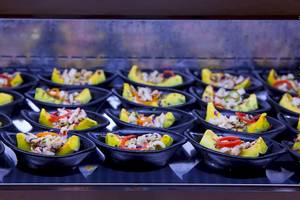 Mehrere Gerichte in schwarzen Schüsseln auf einem Buffet im Le Duc de Praslin Hotel & Villas.