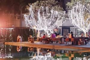 JC Kevin Sathorn Bangkok Hotel Terrasse bei Nacht mit Beleuchtung und Gästen an Tischen.