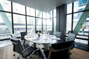 Konferenzraum im Mode Sathorn Hotel mit ovalem Tisch, schwarzen Lederstühlen und großen Fenstern.