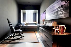 Innenansicht eines Zimmers im Mode Sathorn Hotel mit einem Bett, einem Stuhl und einem Fernseher.