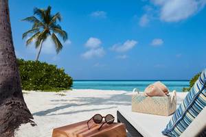 Strand am Amari Havodda Maldives mit Lounge-Bereich, Sonnenbrille und Korb