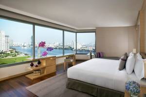 Hotelzimmer im AVANI+ Riverside Bangkok mit Blick auf den Fluss und die Stadt.