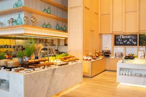 Frühstücksbuffet im AVANI+ Riverside Bangkok mit verschiedenen Gerichten und Utensilien.