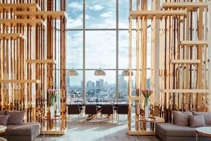 Innenansicht des AVANİ+ Riverside Bangkok Hotels mit goldenen Holzstrukturen und Blick auf die Stadt