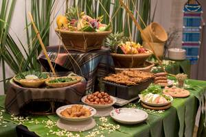 Buffet-Tisch im Novotel Bangkok Sukhumvit 20 mit verschiedenen Gerichten und Früchten.