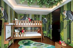 Kinderzimmer im Siam Kempinski Hotel Bangkok mit grünen Wänden und Affen-Wandmalereien.