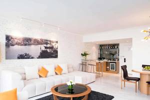 Innenbereich des Pullman Bangkok Hotel G mit weißer Couch, Couchtisch und Bar.