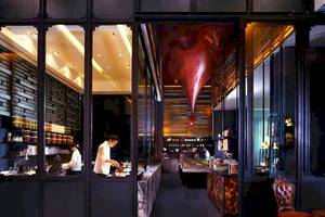 Inneneinrichtung des Restaurants im SO/ Bangkok Hotel mit zwei Köchen und einem roten Designelement.