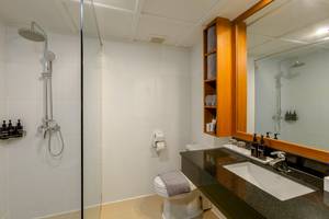 Badezimmer im Sunprime Kamala Beach Hotel mit Dusche, Toilette und Waschbecken.
