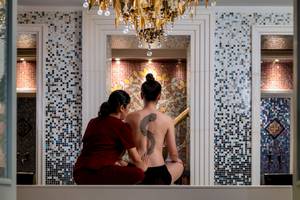 Massagebehandlung im Amatara Welleisure Resort mit einer Therapeutin, die das Rücken eines Kunden bearbeitet.