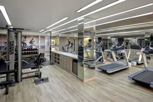 Fitnessstudio im Phuket Marriott Resort & Spa mit Trainingsgeräten und Spiegeln.