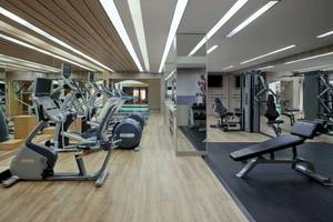 Fitnessstudio im Phuket Marriott Resort & Spa mit modernen Geräten und hellem Holzboden.