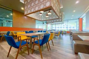 Innenbereich des X10 Khaolak Resorts mit blauen und gelben Stühlen und Tischen, modernes Design, Holzboden.