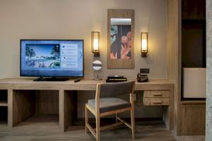 Hotelzimmer im La Flora Khao Lak mit Schreibtisch, Fernseher und Wandlampen