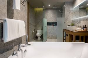 Badezimmer im La Flora Khao Lak Hotel mit Badewanne, Dusche und Waschtisch.