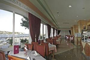Innenansicht des Restaurants im Argos Hotel mit Blick auf den See und gedeckten Tischen.